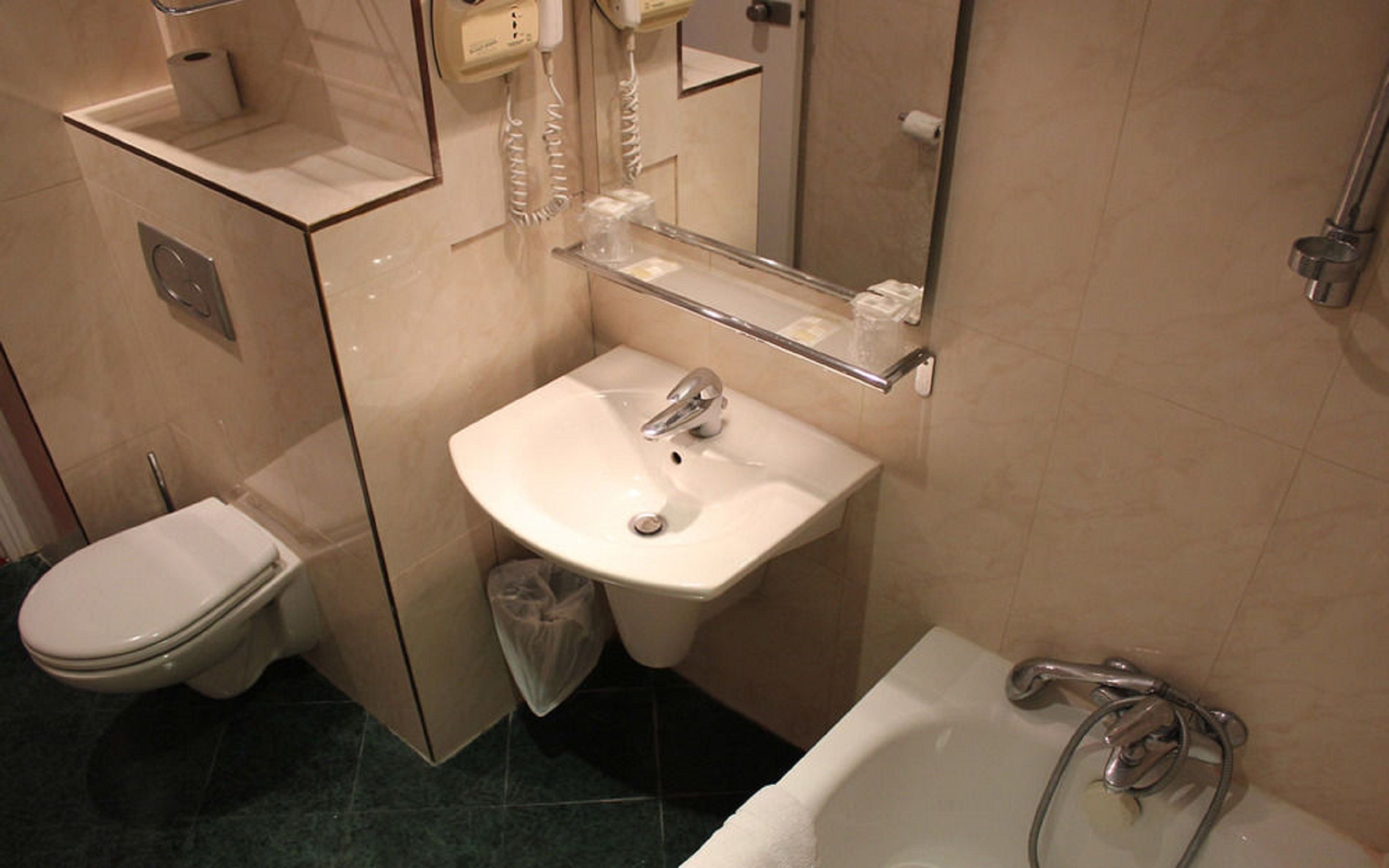 A bathroom with a toilet, sink, and bathtub.