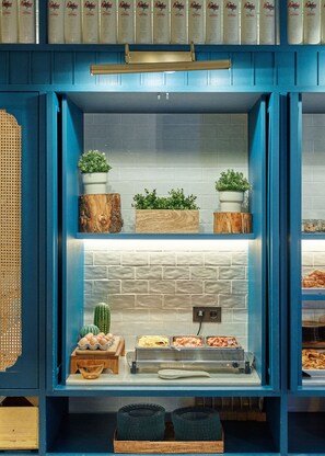 Un bufé de desayuno con diversas opciones de comida y plantas decorativas.
