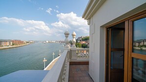 Un balcón con vista a un río y edificios al fondo.