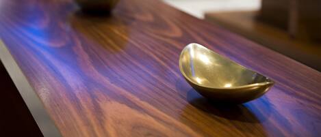 A wooden table with three metallic bowls.