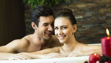 Couples can unwind in a serene spa setting with a bathtub for two, surrounded by a peaceful ambiance.
