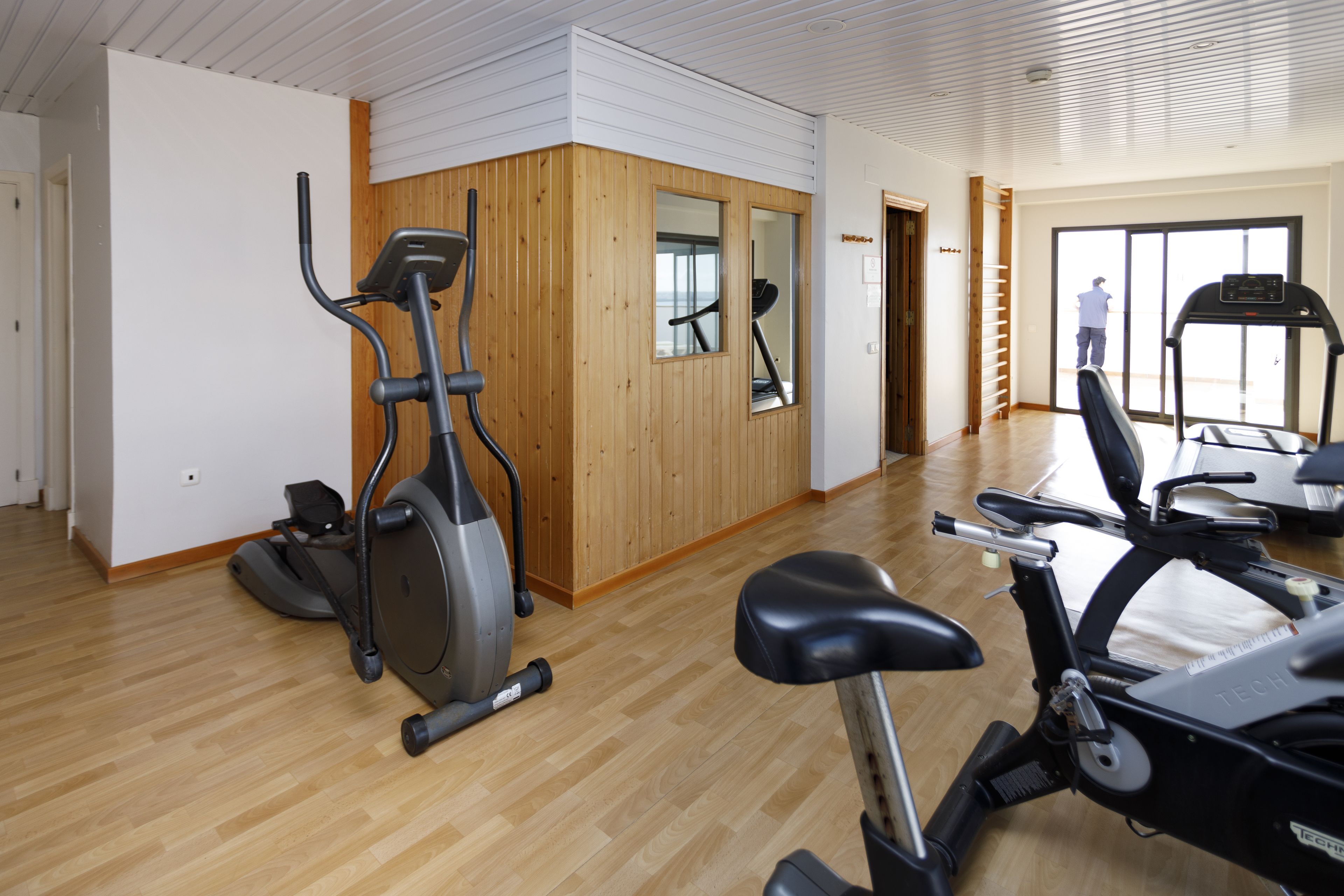 A spacious indoor gym with various exercise equipment, including treadmills and an elliptical machine.