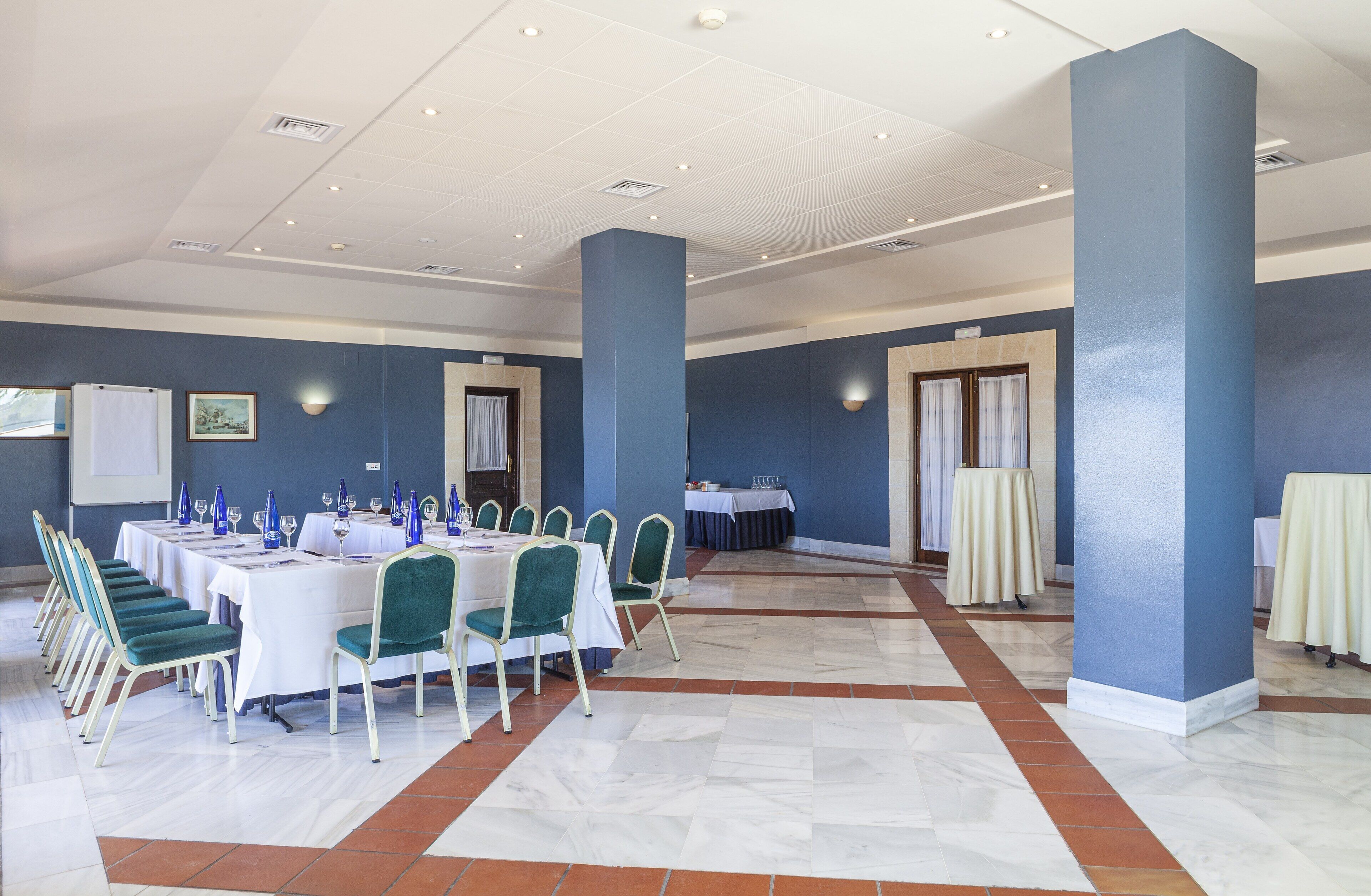 A conference room with a long table, chairs, and a white ceiling.