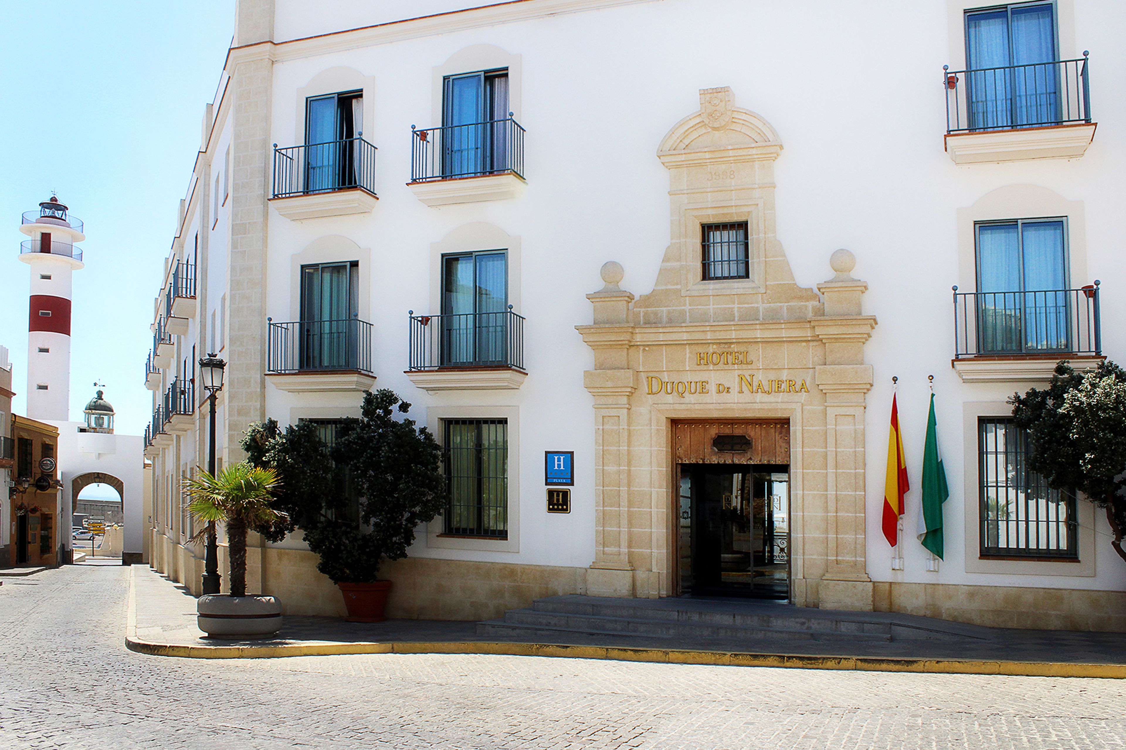 Fachada de hotel com entrada destacada, varandas e bandeiras.