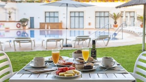 A breakfast table with plates of food, drinks, and a bottle of olive oil. - Hotel Duque De Najera (Rota)