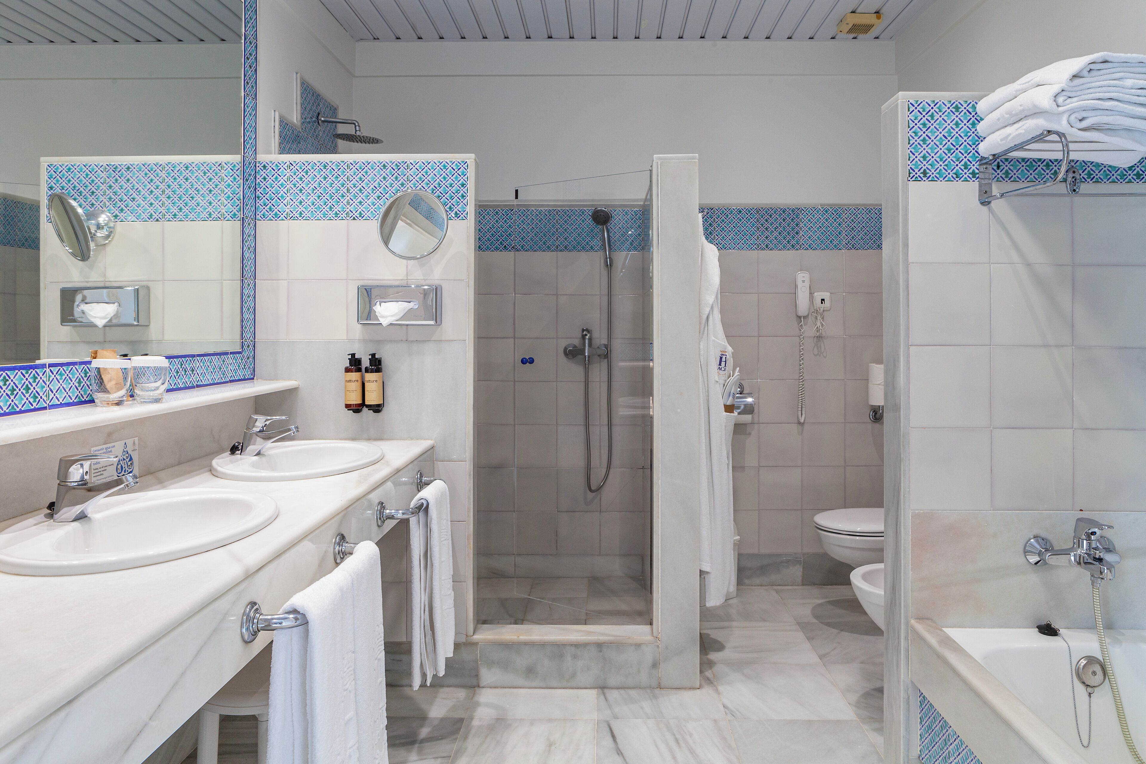 A modern bathroom with two sinks, a shower, and a toilet.