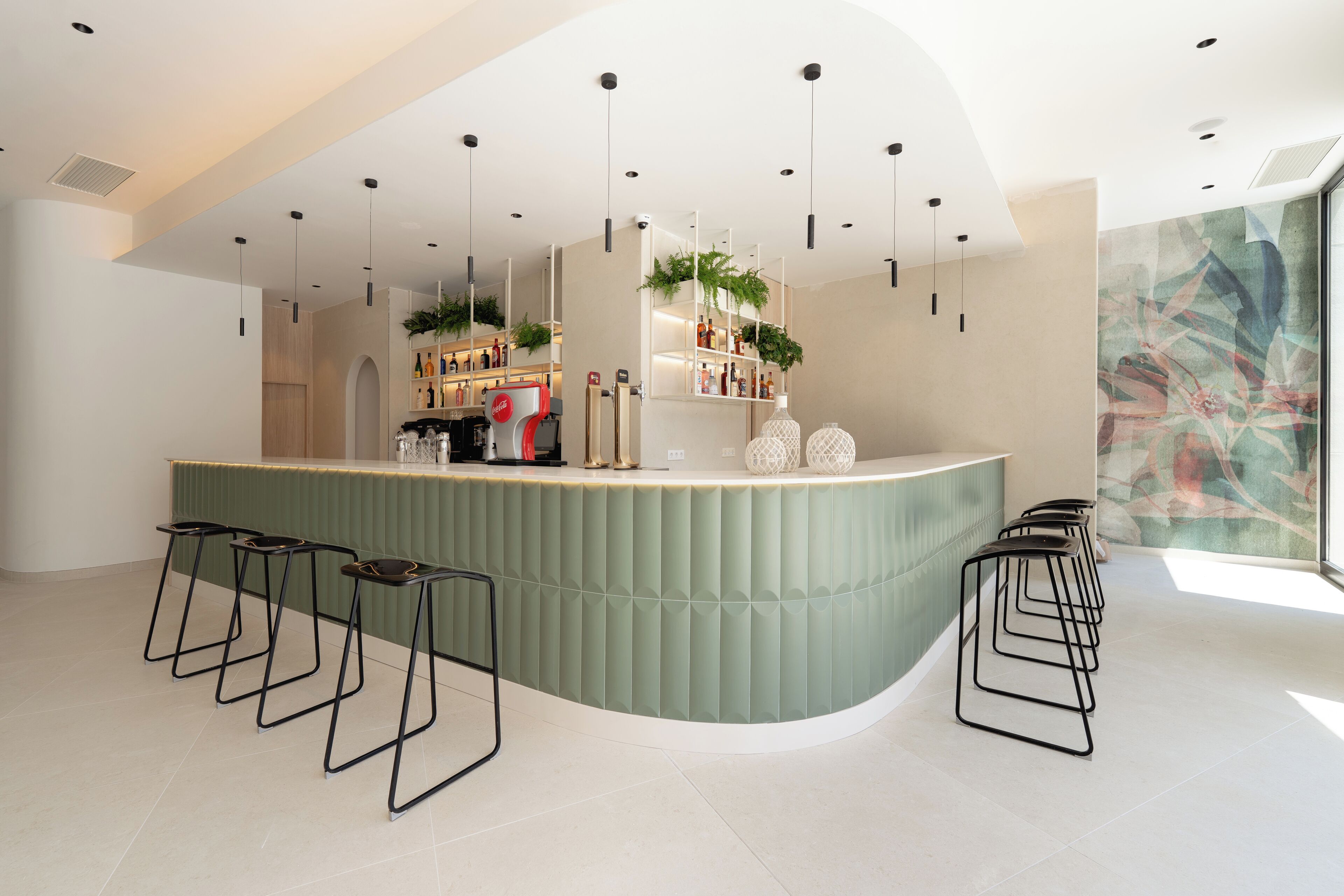 A modern bar area with a curved counter, multiple stools, hanging plants, and a large window with a view.