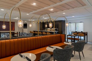 A modern interior with a seating area, tables, and a bar. - Hilton Garden Inn Arlington/Courthouse Plaza (Arlington)