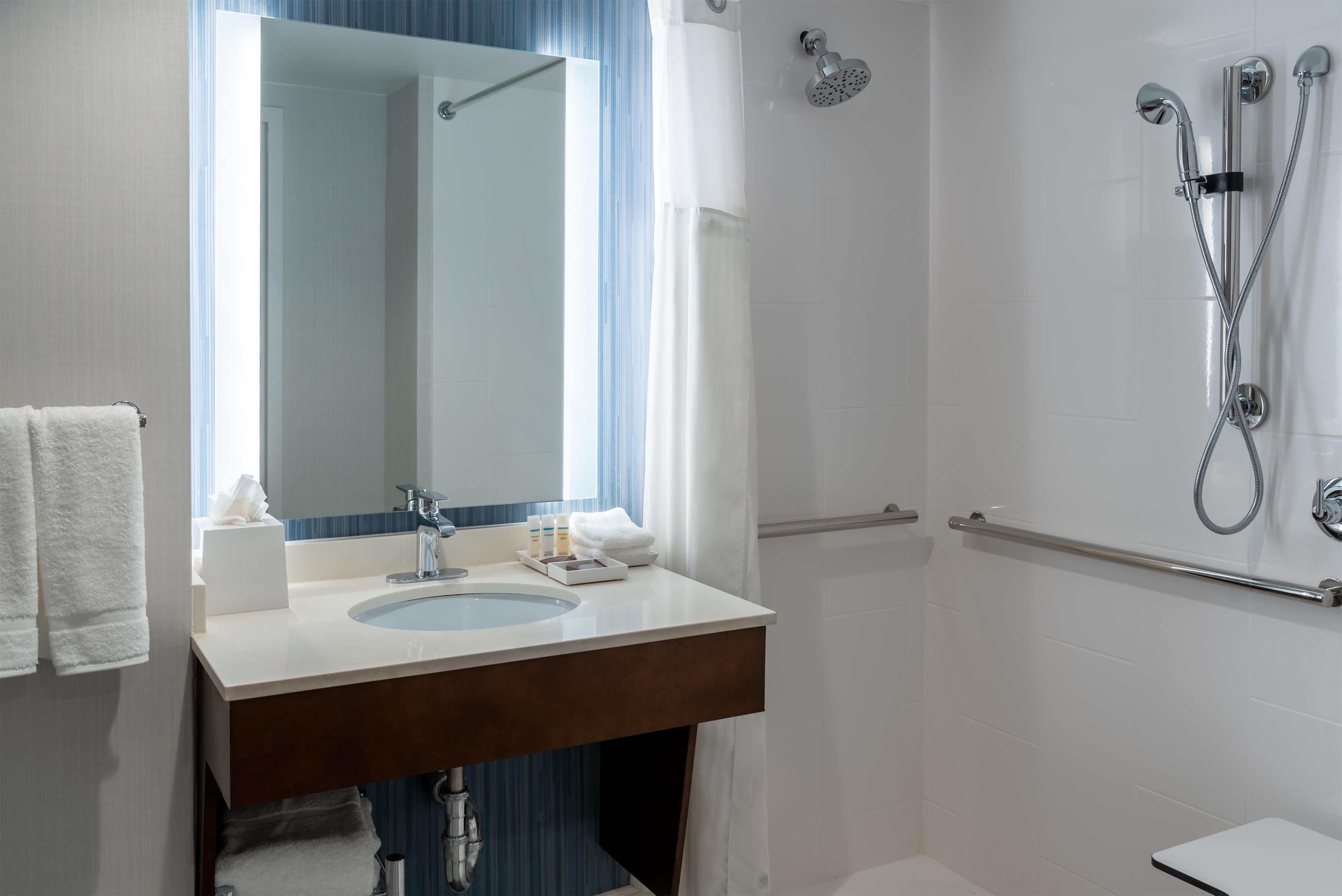 Un baño con lavabo, espejo, ducha e inodoro.