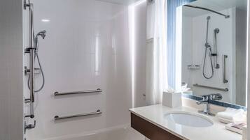 Une salle de bain moderne équipée d’une baignoire, d’une douche, d’un lavabo et d’un miroir.
