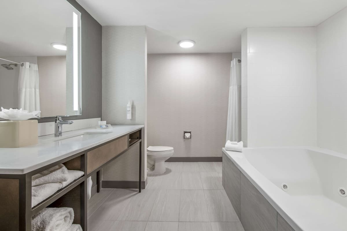 king bed with whirlpool | bathroom | combined shower/bathtub, free toiletries, hair dryer, towels