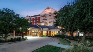 A Hilton Garden Inn with a modern design, featuring a large entrance, multiple floors, and a well-maintained outdoor area with trees and landscaping.