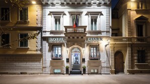 A historic hotel facade with a grand entrance, columns, and a balcony with flags. - LHP Hotel River & SPA (Florence)