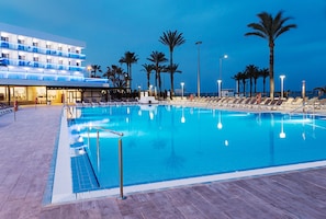 A large indoor swimming pool with lounge chairs and palm trees, surrounded by a modern hotel building. - Hotel Best Sabinal (Roquetas de Mar)