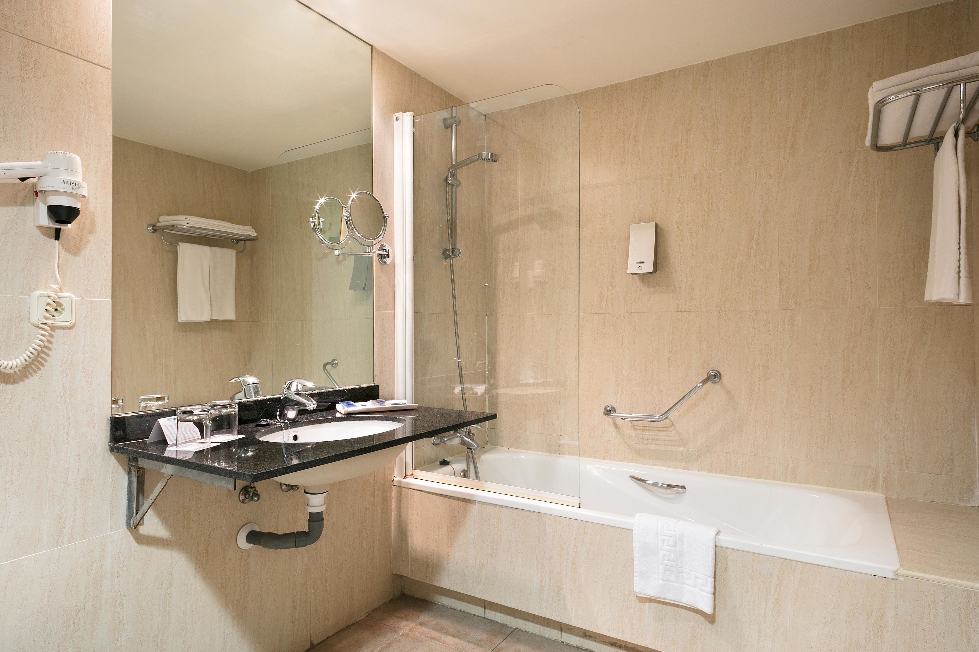 A modern bathroom with a sink, mirror, and shower.