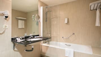 A modern bathroom with a sink, mirror, and shower.