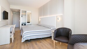 Una habitación de hotel moderna con cama, escritorio, silla y armario.