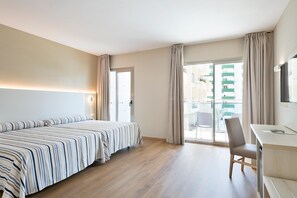 A hotel room with a bed, a desk, and a chair. There is a window with curtains and a view of buildings outside. - Hotel Best Sabinal (Roquetas de Mar)