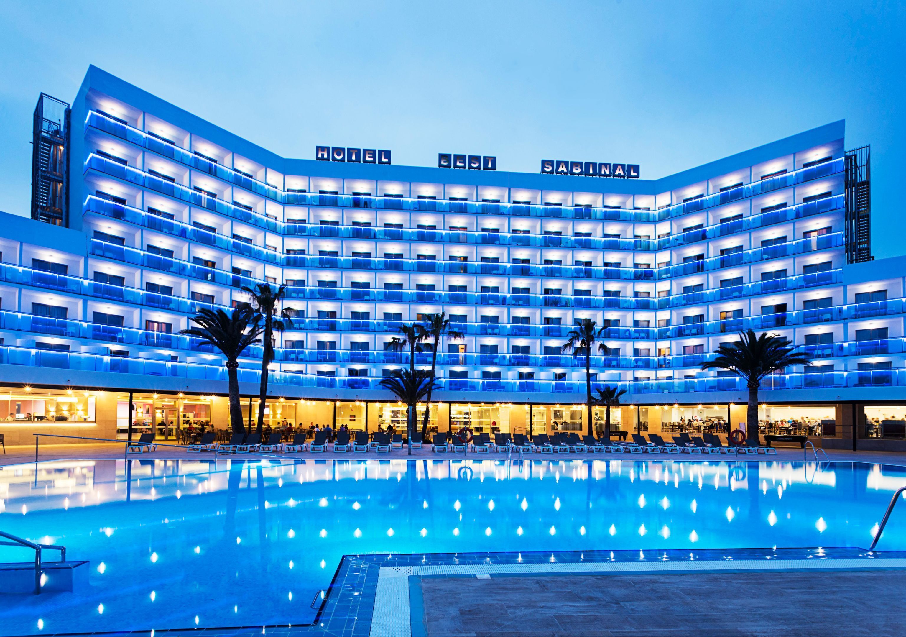 Un hôtel à plusieurs étages avec une piscine en premier plan.