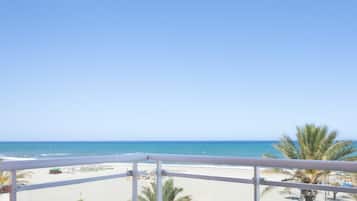 A balcony with a view of a beach and ocean.