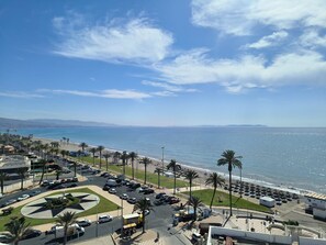 A coastal cityscape with a beach, palm trees, and a clear blue sky. - Hotel Best Sabinal (Roquetas de Mar)