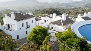 A white building with a tiled roof, a swimming pool, and a view of the surrounding hills. - Villa Turística de Priego de Córdoba (Priego de Córdoba)