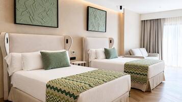 Habitación de hotel con dos camas, ventilador de techo, obras de arte en las paredes y una ventana con cortinas.