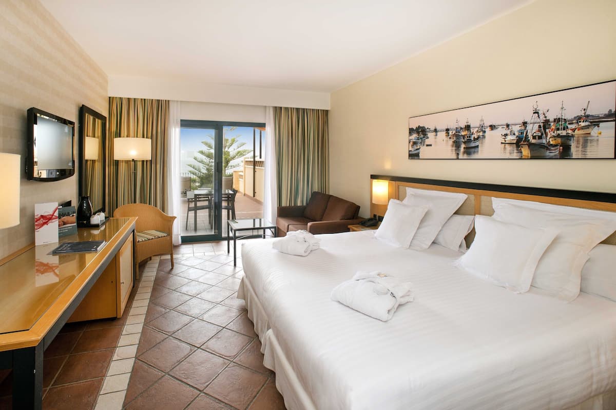 Deluxe Room, Pool View | Minibar, in-room safe, desk, blackout drapes