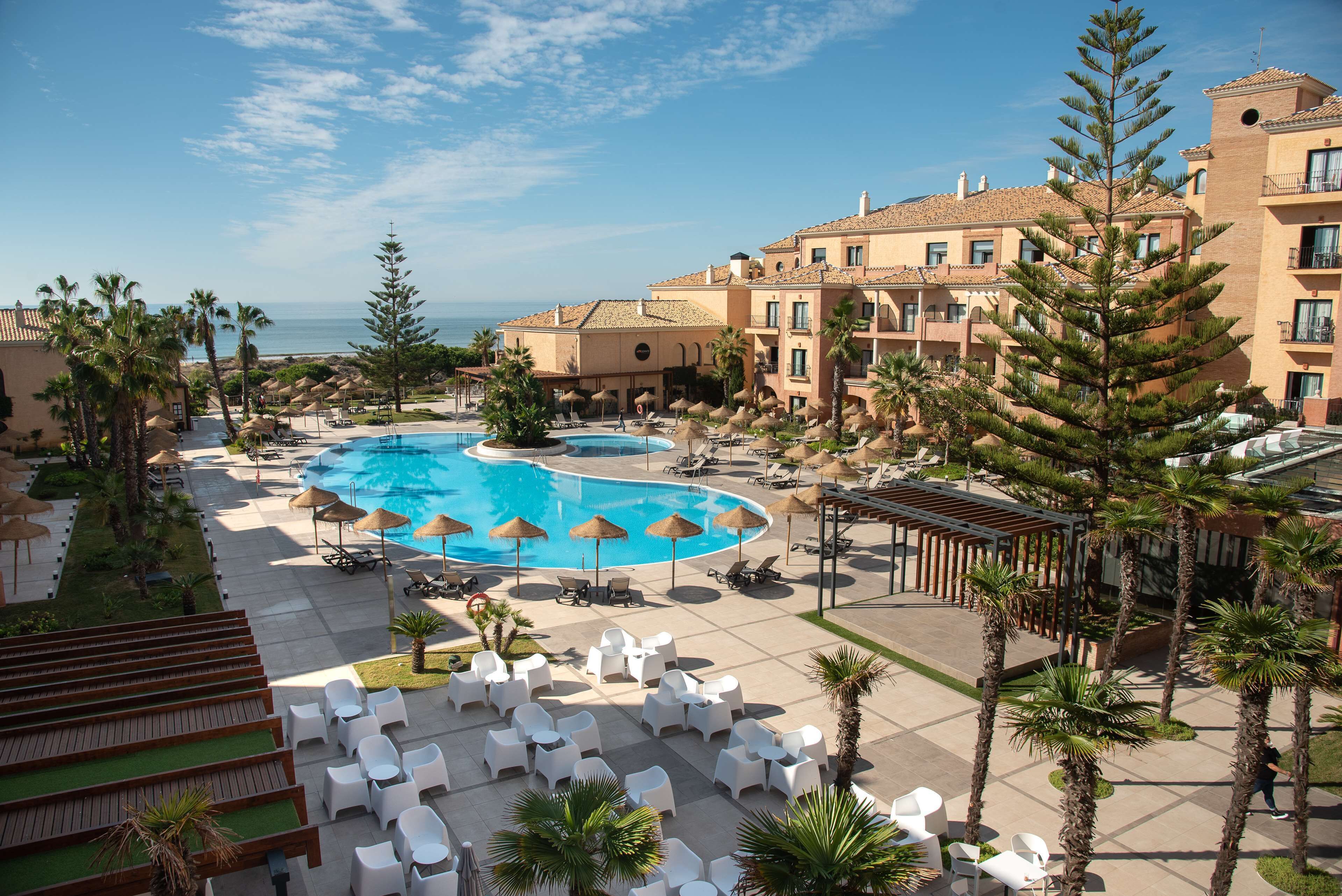 Een buitenzwembad, parasols bij het zwembad en ligstoelen