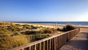 A wooden boardwalk leading to a beach with dunes and sparse vegetation. - Barceló Punta Umbría Mar (Punta Umbría)