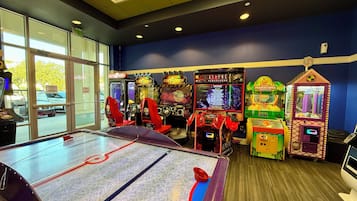 An indoor arcade with various gaming machines and a table hockey setup.