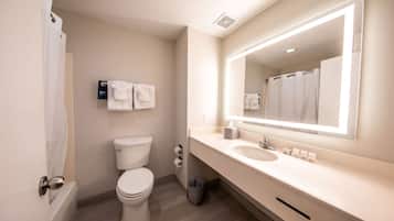 Un baño moderno con inodoro, lavamanos y espejo.