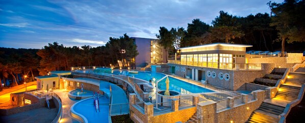 Una piscina al aire libre, sombrillas, sillones reclinables de piscina