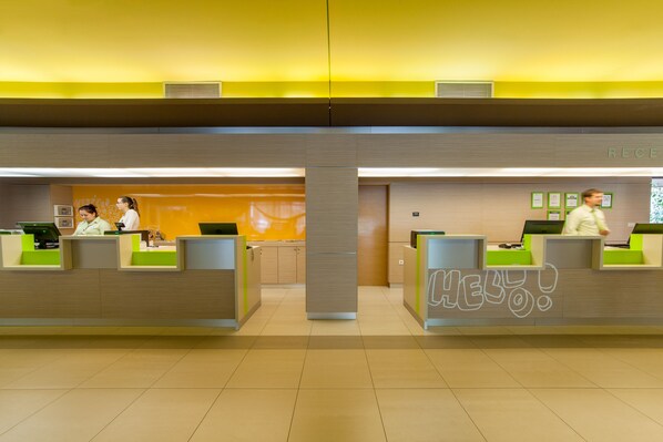 A reception area with two reception desks, a counter, and a wall with framed certificates. - Family Hotel Vespera (Mali Losinj)