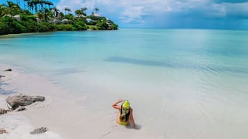 På stranden, hvit sand, strandtelt (inkludert) og solsenger