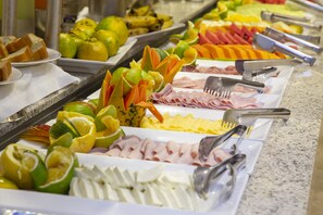 A buffet with various food items including sliced meats, cheeses, and fruits. - Golden Tower Pinheiros by Fênix Hotéis (São Paulo)