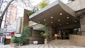 A hotel entrance with a checkered floor, a sign indicating the entrance, and a staircase leading to the lobby. - Golden Tower Pinheiros by Fênix Hotéis (São Paulo)
