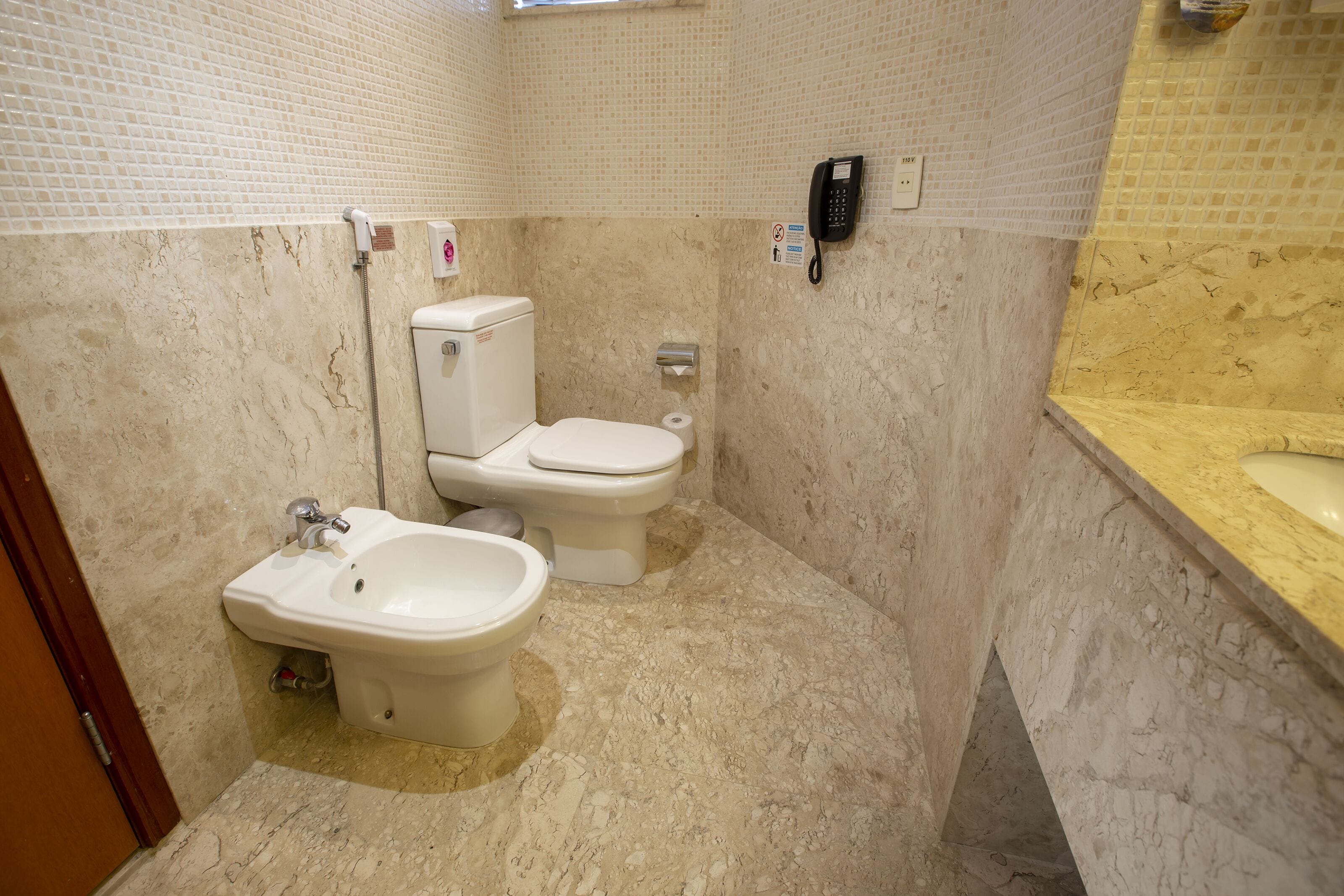 Un baño con inodoro, bidé y lavamanos.