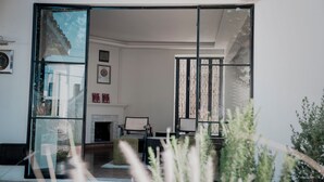 A modern interior with a fireplace, a glass partition, and a view of the outdoors. - Casa Bonita Hotel & Luxury Residence (Oaxaca)