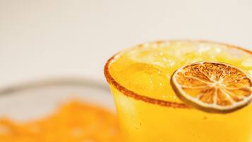 Un verre de jus d’orange, avec une tranche d’orange séchée sur le bord.