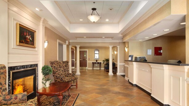 A spacious lobby with a fireplace, comfortable seating, a reception desk, and a view into the dining area. - Days Inn by Wyndham Altavista (Altavista)