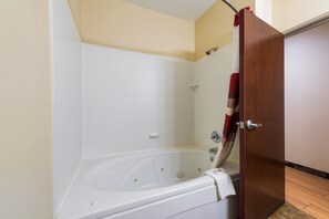 Suite, 1 King Bed, Non Smoking, Jetted Tub | Bathroom | Hair dryer, towels, soap, shampoo