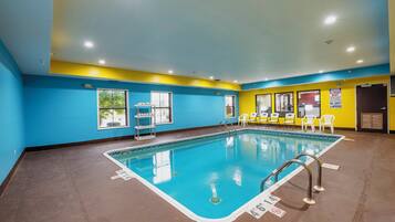 Swimmers can enjoy a refreshing dip in the rectangular pool surrounded by a seating area with chairs.