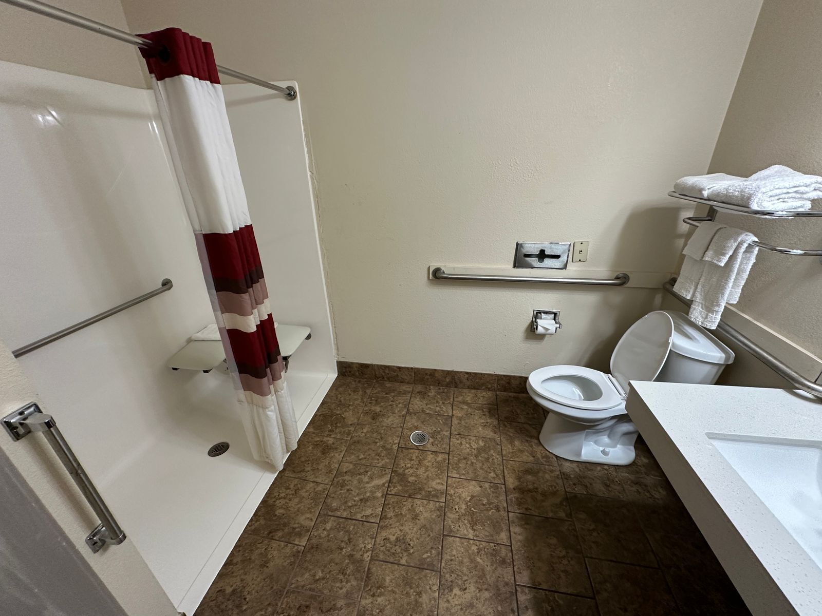 A bathroom with a shower, toilet, and sink.