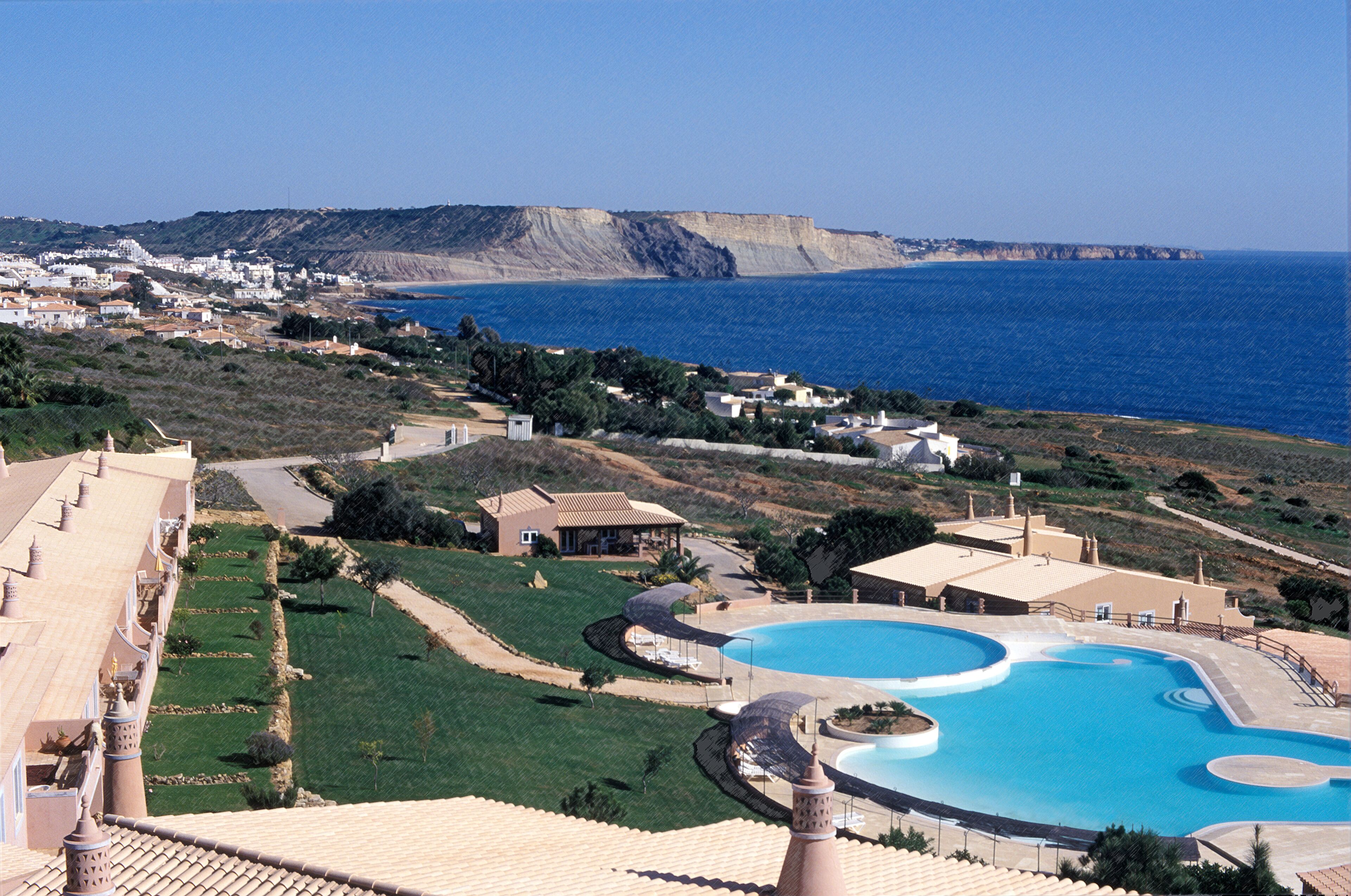 Un complexe hôtelier doté d’une grande piscine, de vastes pelouses verdoyantes et offrant une vue sur la mer.