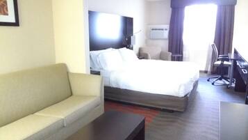 Une chambre d’hôtel avec un lit, un canapé, un bureau et une télévision.
