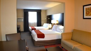 Une chambre d’hôtel avec deux lits, un canapé, un bureau et une chaise.