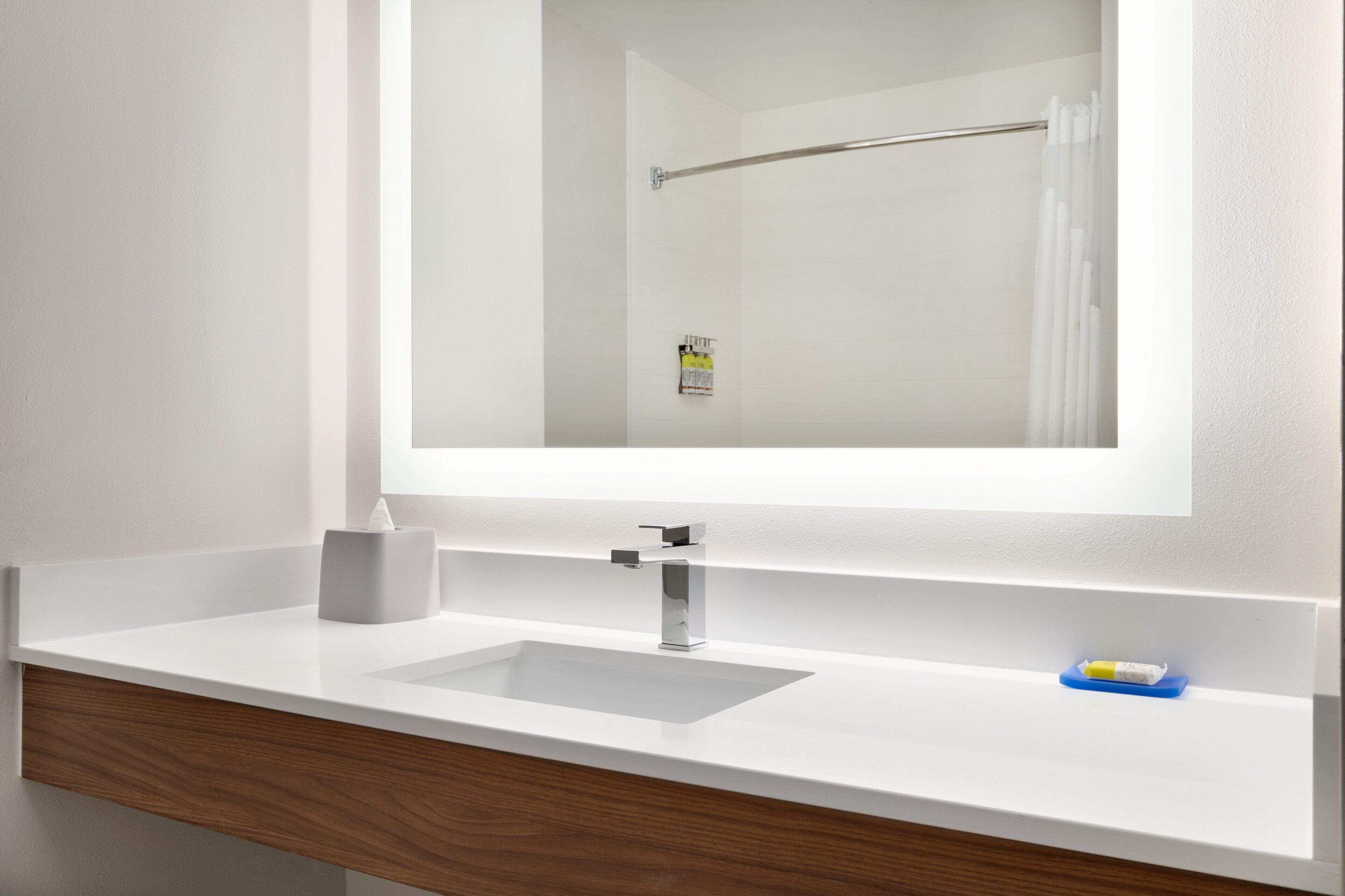 Une salle de bain avec un lavabo blanc, un miroir et un porte-serviettes.