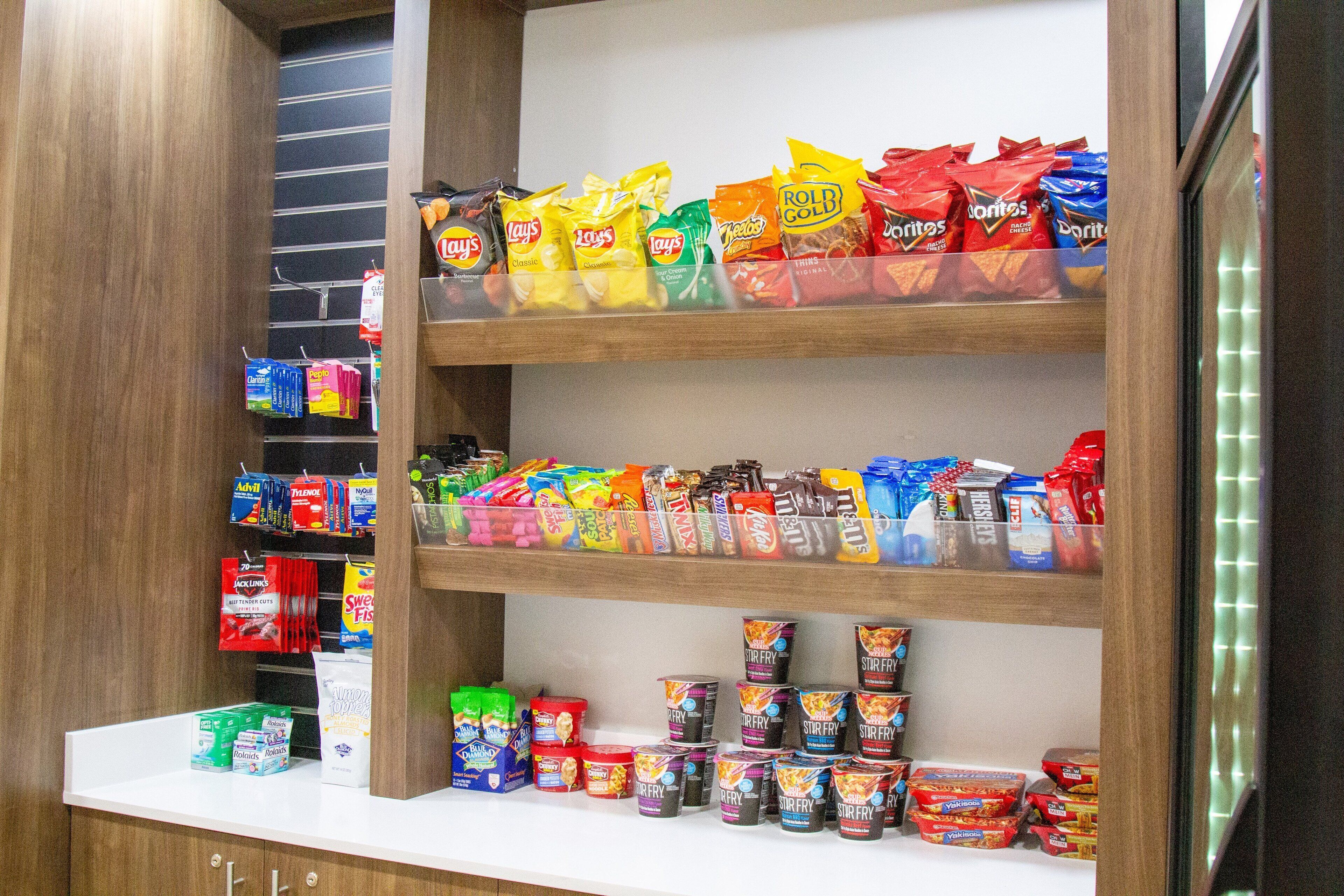 A snack aisle with various chips and frozen foods.