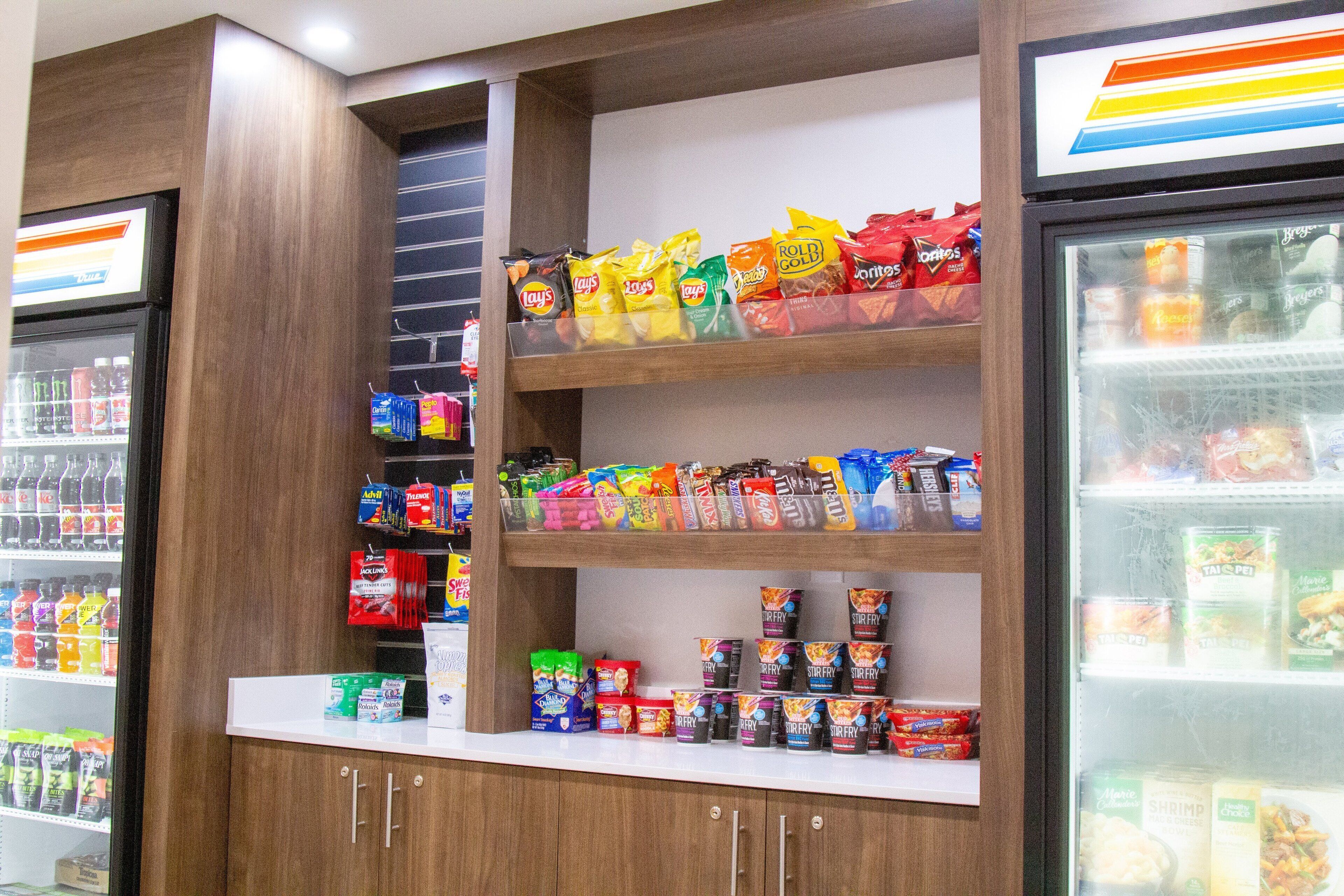 A snack and beverage display in a store with various snacks and drinks on shelves.